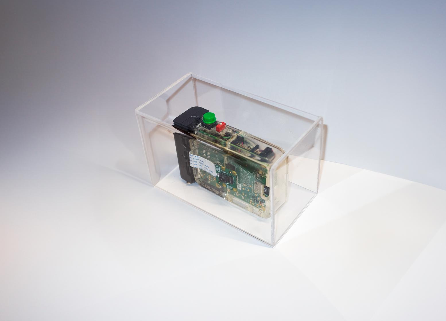 The original Cámara Poética physical camera inside a transparent enclosure.